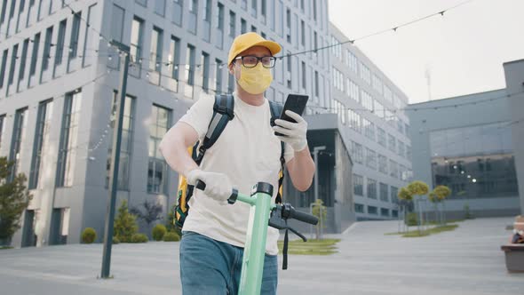 The Vendor Looks at the Smartphone Screen and Talks on the Phone on the Street alt