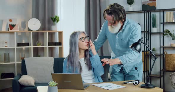 Mature Couple Talking when Reading fresh News on Laptop Screen being alt