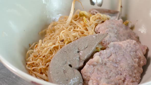 Close-up Footage of Thai Styled Egg Noodles With Minced Pork Cake and Pork Liver, Thailand Popular S alt