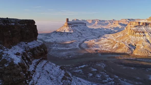 Aerial view panning across cliff viewing winter landscape in the Utah desert alt