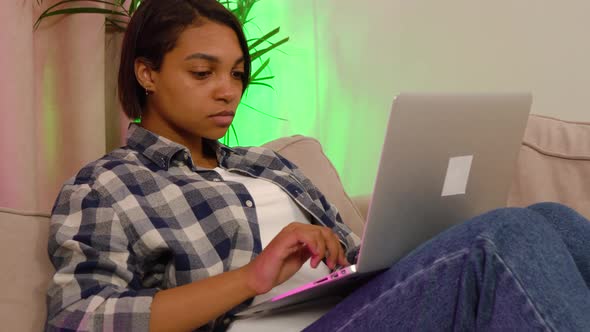 Young Woman Lying at Home on the Couch Working or Studying Online