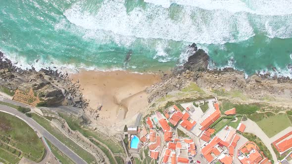 Aerial view of beach and cliffs next to Azenhas do Mar Village. alt