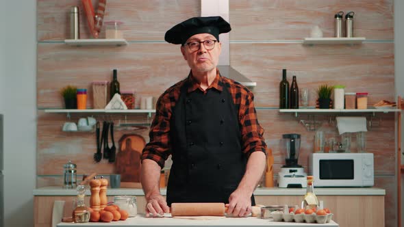 Elderly Man Rolling the Dough at Video Camera alt