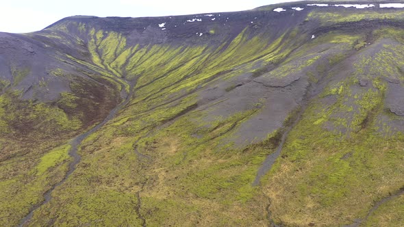 Flying Over a Volcanic Field with Vibrant Green Moss in Iceland alt