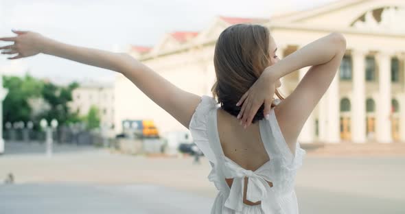 360 Camera Shot Young Dancer in White Dress Dances on the Stairs of the Theatre in Slow Motion alt