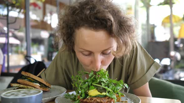 Joyful Starving Young Woman Eats Her Vegan Toast Without Hands alt