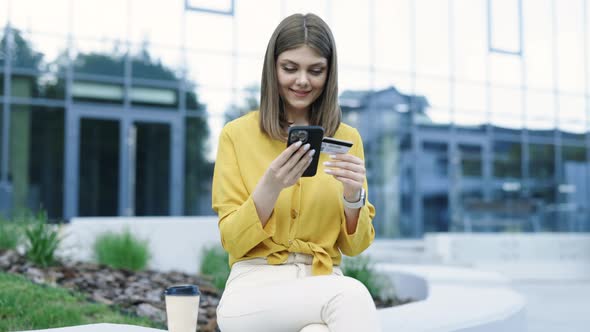 Caucasian Woman Holding Credit Card Using Digital Mobile Device and Buying Online Internet Shopping