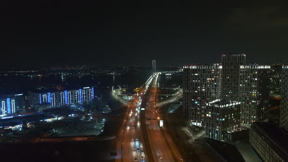 Modern Skyscrapers near the Bridge at the Night Aerial View City Traffic alt