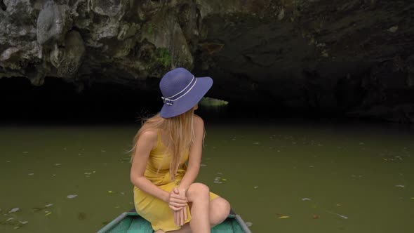 Slowmotion Shot of a Young Woman on a Boat Having a River Trip Among Spectacular Limestone Rocks in alt