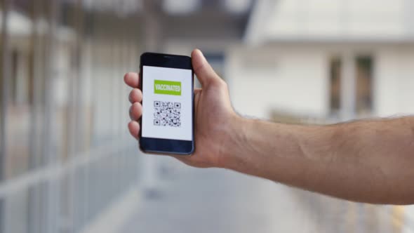 Dolly Push Shot of Male Hand Holding Mobile Phone with Vaccinated Qrcode alt