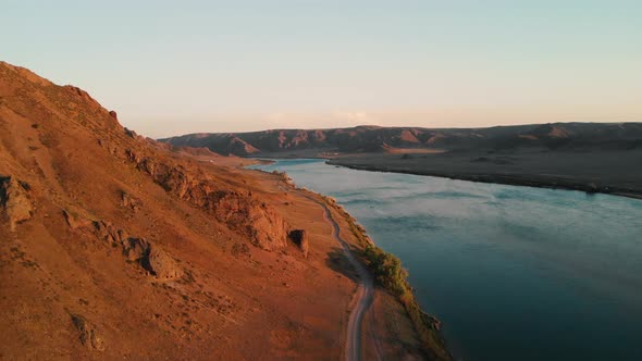 Drone Shot of River and Mountains at Sunset in Kazakhstan alt