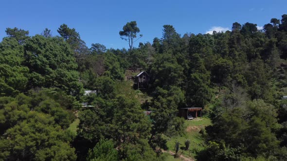 Drone shot of an eco farm in Hogsback, South Africa - drone is reversing from a self made guest room alt