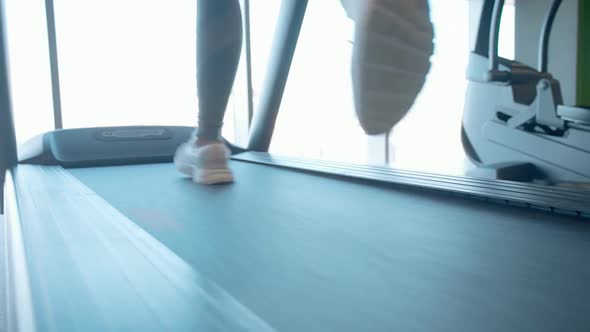 Lady Running on Professional Treadmill in Gym