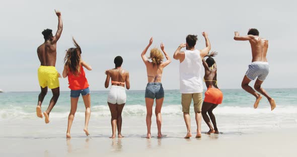 Group of mixed-race friends dancing together on the beach 4k alt