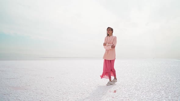 Wonderful Dreamy Woman in Big Sweater and Pink Dress Posing at Windy Salty Coastline on Pink Salt alt