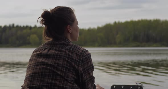 Young Beautiful Girl Sits in an Inflatable Boat on the Lake alt
