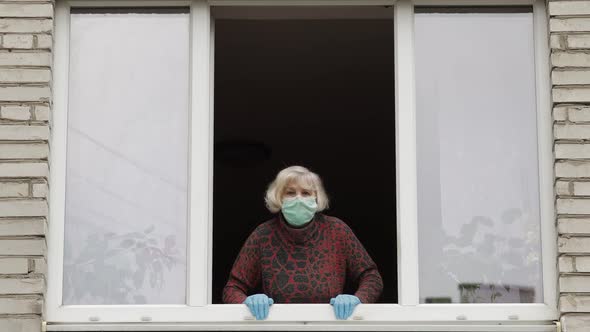 Old Woman Grandmother Stay at Window Isolated at Home on Quarantine. Coronavirus alt