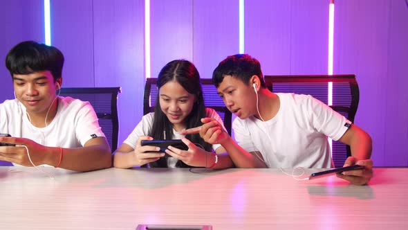 Team Of Asian Gamers Playing In Competitive Video Games On A Cyber Games Tournament By Mobile Phone alt