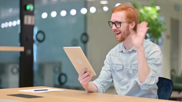 Professional Young Redhead Man Doing Video Call on Tablet alt
