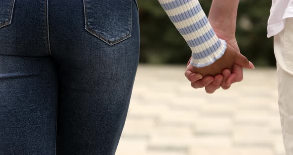 Love couple holding hands on urban background.