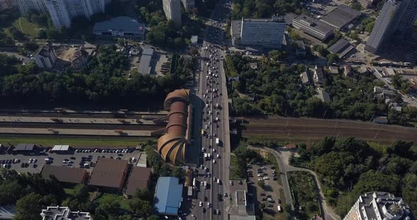 Cars cross the bridge over the railway tracks in the city center on the freeway in traffic. Railway 