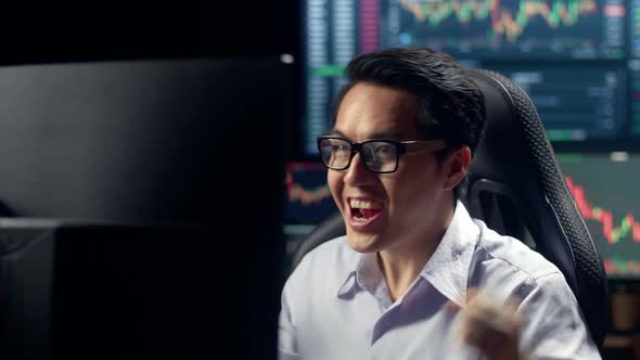 Broker Working On Computer And Celebrating With Analyzing Graphs On Multiple Computer Screens alt