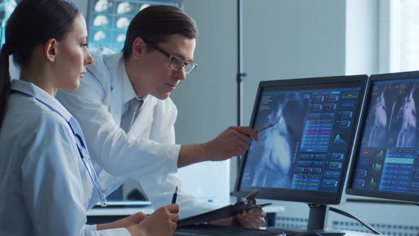 Professional medical doctors working in hospital office making computer research. alt