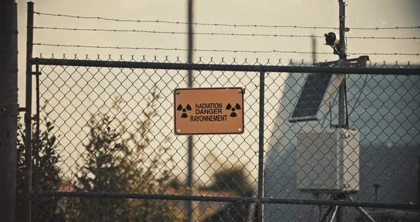 Radiation Danger Sign on Barbed Wire Fence with Radioactive Particles in Slow Motion 4K alt