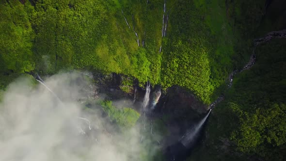 Aerial view above waterfall surrounding by jungle, Faroe Island. alt