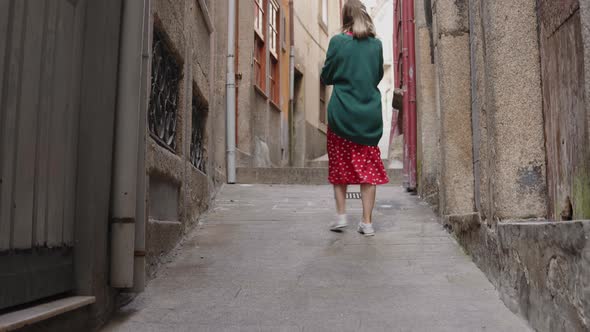 Woman Tourist Is Walking and Taking Photos in Ancient Street, Portugal alt