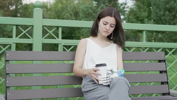 Girl is drinking a coffee Bionics Cybernetic Robotic-arm Hand prosthesis alt