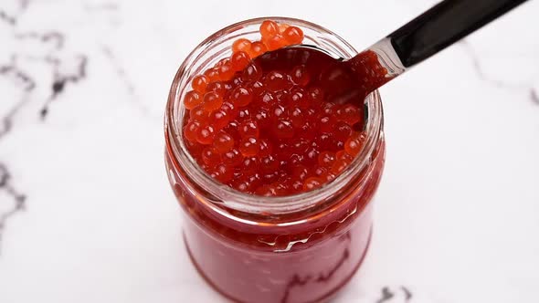fresh red caviar of chum salmon in a glass jar alt