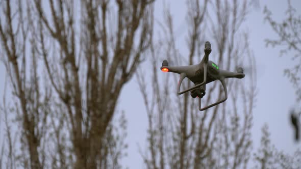 Flying Drone with Camera Between Trees