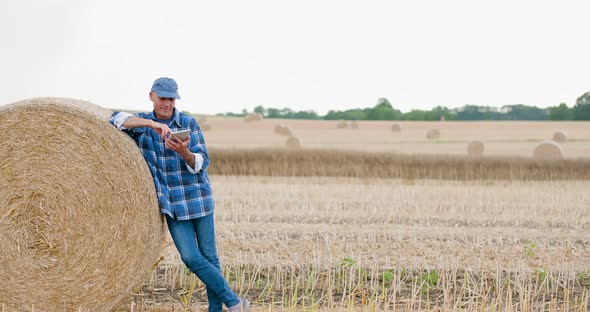 Farmer Using Digital Tablet While Examining Farm alt