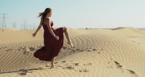 Vacation in Dubai Young Lady in Red Dress is Dancing in the Desert alt
