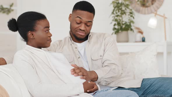 Young African Couple Married Newlyweds Spouses Afro Ethnic Black Family Sitting on Sofa at Home alt