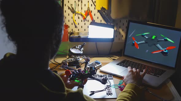 Technician with Detail Searches Quadrocopter Model on Laptop