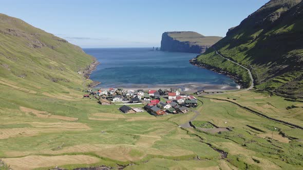 Drone Shot of Small Houses By the Ocean Waters in Tjornuvik Faroe Islands alt