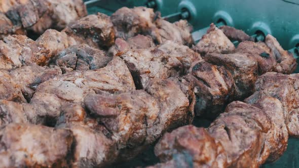 Shish Kebab on Skewers Is Cooked on the Automatic Grill at Street Food Festival. alt