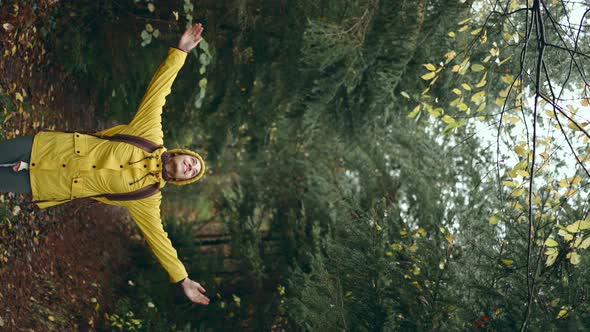 Vertical Portrait Tourist Woman in Yellow Jacket at Forest Standing Looking Around Inspiring Fall alt