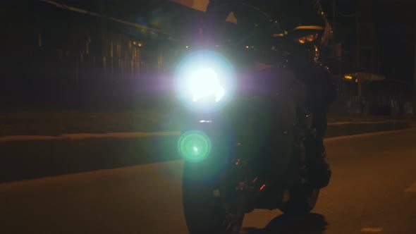Man Riding on Modern Sport Motorbike with Headlights on at Night alt