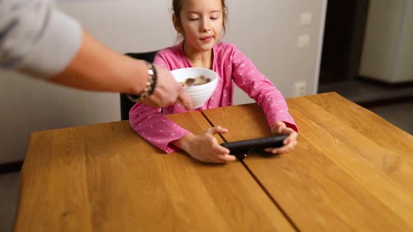 Little girl play game on smartphone, dad takes the phone away,