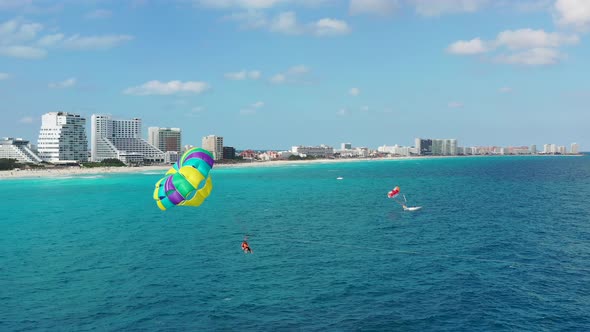 Camera pans to show parasailers near Cancun's resorts alt