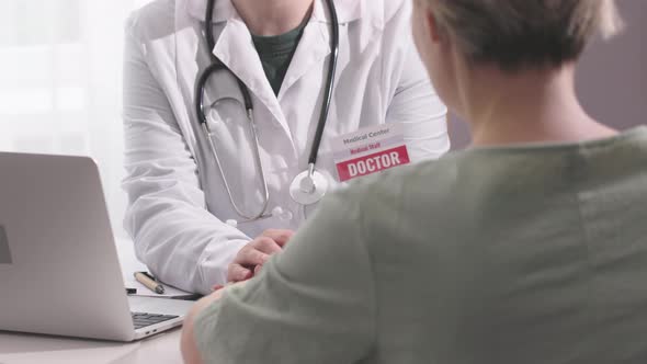 Female Doctor Talking to Woman Patient During Medical Appointment Clinic Office alt