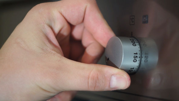 Person Turning Knob to Turn on Stove 2
