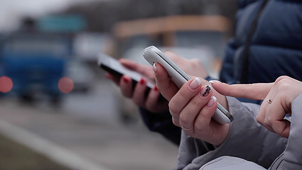 Girls on Street Use Mobile Phone alt
