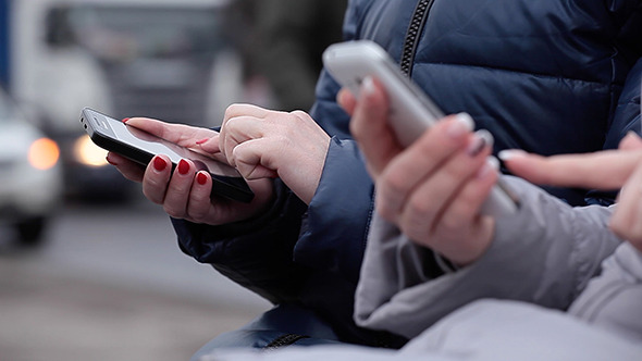 Women on Street Typing Text With Mobile Phone alt