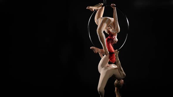 Wide Shot Two Flexible Women Hanging on Air Hoop Spinning at Black Background Performing Tricks alt