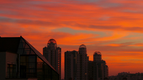 Clouds Passing by Over City at Sunset