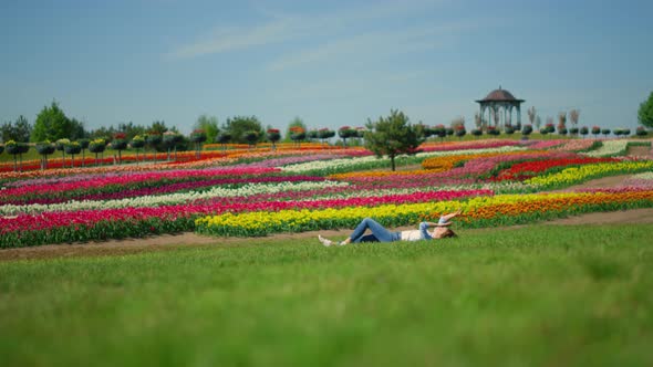 Young Unknown Woman Standing Up in Grass on Blooming Flower Field Background alt